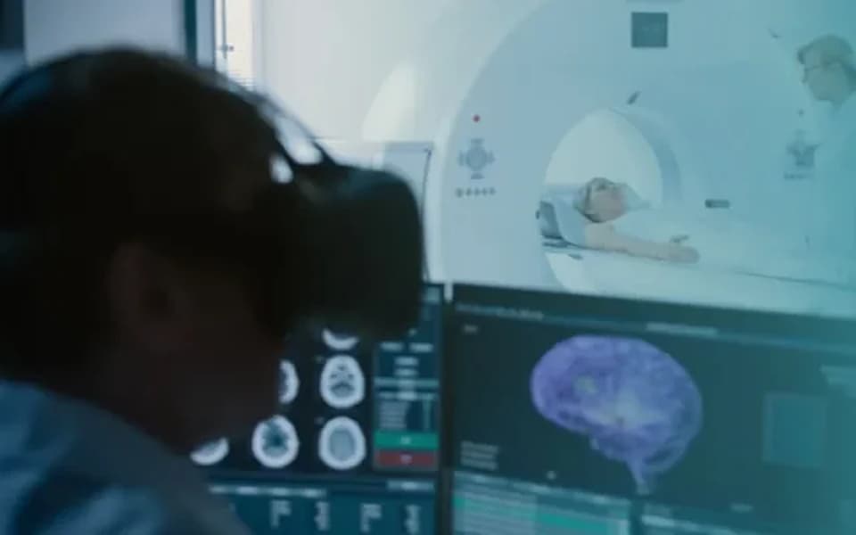 Especialista analisa imagens de exames do cérebro em monitores