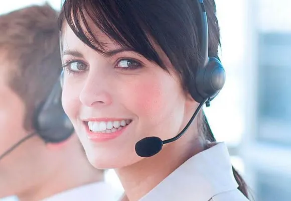 Atendente sorridente com fone de ouvido em central de atendimento